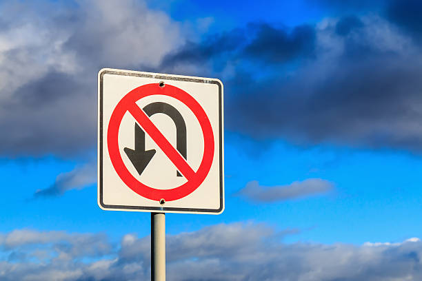 No U Turn traffic sign against cloudy sky.